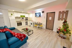 ein Wohnzimmer mit einer blauen Couch und einem Weihnachtsbaum in der Unterkunft Adam and Eve Luxury Apartments - Shabbat Friendly in Bukarest
