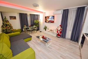 ein Wohnzimmer mit einem Weihnachtsbaum und einem Weihnachtsmann in der Unterkunft Adam and Eve Luxury Apartments - Shabbat Friendly in Bukarest