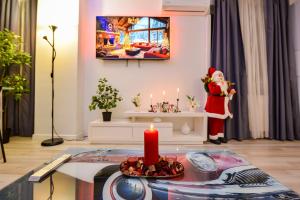 Ein Weihnachtszimmer mit einem Weihnachtsmann und einer Kerze in der Unterkunft Adam and Eve Luxury Apartments - Shabbat Friendly in Bukarest + 116 Fotos