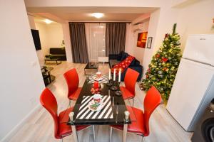 ein Wohnzimmer mit einem Weihnachtsbaum, einem Tisch und Stühlen in der Unterkunft Adam and Eve Luxury Apartments - Shabbat Friendly in Bukarest