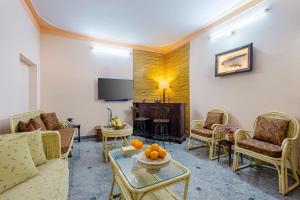 a living room with a couch and chairs and a tv at Alaya Stays Abhimanyu Mansion Pearl 6 BHK Mansion with Rajasthani Decor in Udaipur