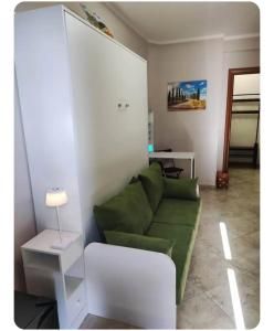 a living room with a green couch and a table at Nella dolce Grotta in Monsummano Terme