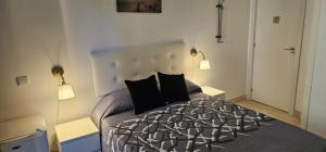 1 dormitorio con 1 cama con 2 almohadas negras en Habitaciones Chueca, en Madrid 8 fotos más