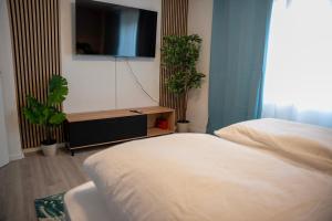 a bedroom with a bed and a flat screen tv at Stilvoll Apt - Balkon - Netflix in Saarbrücken