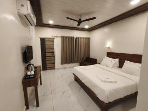 une chambre avec un lit et un ventilateur de plafond dans l'établissement Mount Bliss Resort, à Mhasla
