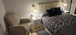 a bedroom with a bed and a chair at Habitaciones Chueca in Madrid +12 photos