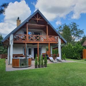 a house with a deck and a grill in the yard at Dom Rodzinny w Okunince Willa Deluxe in Okuninka