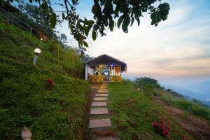 un petit bâtiment à flanc de colline dans l'établissement Snow Smile Camps Munnar, à Munnar