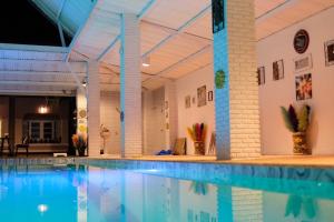 a large swimming pool with blue water in a building at Wara Pool Villa Sam Roi Yot in Baanphakrimlay 