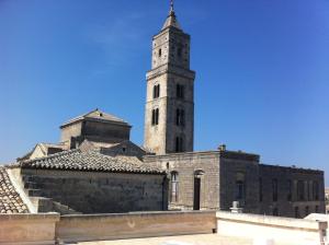 un bâtiment avec une tour d'horloge en haut dans l'établissement l'angolo di Frima, à Matera