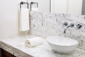 uma casa de banho com um lavatório branco e um balcão de mármore em Hotel Luciano K em Santiago