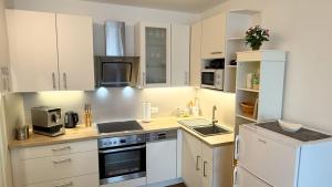 a small kitchen with white cabinets and appliances at Komfortables Appartement/Garconniere in Graz für Urlaub und Geschäftsreisen in Graz