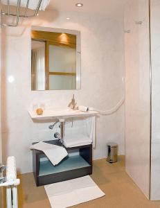 a bathroom with a sink and a mirror at Hotel Casa El Rapido in Felechosa