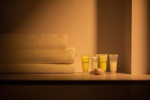 four yellow glasses sitting on a counter next to towels at La Dimora Homestay in Kirtipur