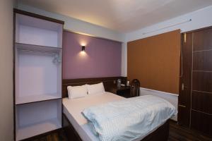 a small bedroom with a bed and a closet at La Dimora Homestay in Kirtipur