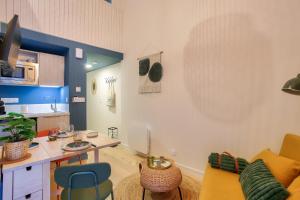 a living room with a yellow couch and a kitchen at 250m de la plage - Charmant studio in La Richardais +10 photos