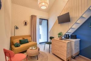 a living room with a yellow chair and a staircase at 250m de la plage - Charmant studio in La Richardais