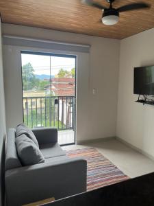 a living room with a couch and a flat screen tv at Moradas de Ibicuí - Mangaratiba in Mangaratiba +25 photos