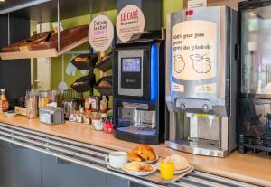 a bakery counter with a coffee machine and pastries at B&B HOTEL Troyes Barberey in Troyes