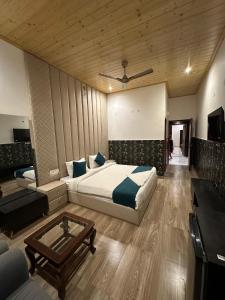 a bedroom with a bed and a table and a couch at La Casca Experience in Zirakpur +30 photos