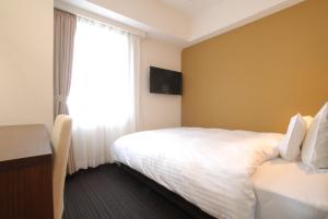 Postel nebo postele na pokoji v ubytování AB Hotel Kanazawa