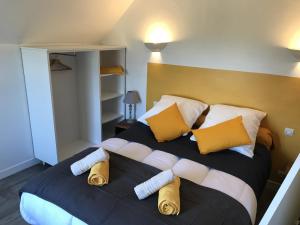 a bedroom with a large bed with yellow and white pillows at Treas Glaz in Plouescat