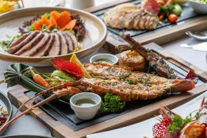 a buffet of food with lobster and other foods at TreeHouse Villas Koh Yao - Adults Only in Ko Yao Noi