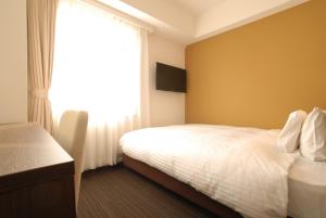 Postel nebo postele na pokoji v ubytování AB Hotel Kanazawa