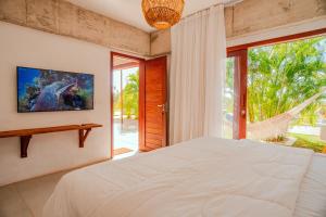 Un dormitorio con una cama grande y una ventana grande. en Santa Maria Inn, en São Miguel do Gostoso