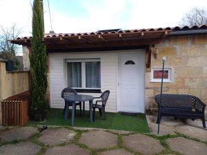 a table and chairs in front of a house at Ambiance chalet in Prignac-et-Marcamps