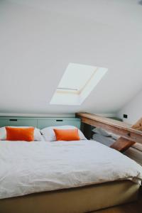 a bed with two orange pillows in a room at Apartmán Kukučínova in Banská Bystrica
