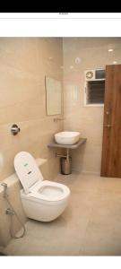 a bathroom with a toilet and a sink at RadhaKrishna Executive in Tuljapur +17 photos