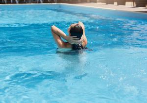a woman sitting in the water in a swimming pool at Sunny Baltic in Jarosławiec