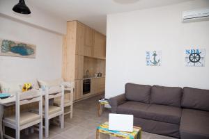 a living room with a couch and a table at Prokymaia Penthouse Apartment in Rethymno