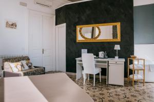 a bedroom with a bed and a desk with a mirror at B&B I Puritani in Catania