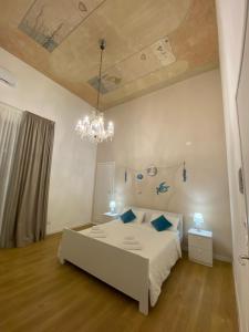 una camera da letto con un letto bianco e un lampadario di Clemente House Catania Centro MERAVIGLIOSA camera matrimoniale a Catania
