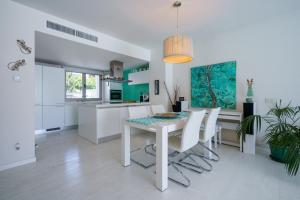 cocina blanca con mesa de comedor y sillas en Torre Blanca, en Palma de Mallorca