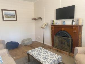 a living room with a fireplace with a flat screen tv at Relaxing on Vale B & B in Nagambie