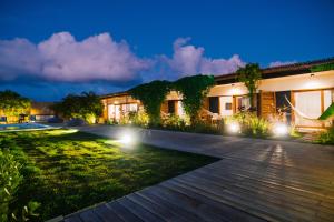 una casa con jardín por la noche en Santa Maria Inn, en São Miguel do Gostoso