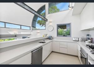 una cucina con mobili bianchi e una grande finestra di Vue De Vague a Lorne