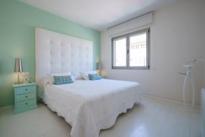 Un dormitorio blanco con una cama grande y una ventana. en Torre Blanca, en Palma de Mallorca 8 fotos más