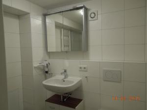 a white bathroom with a sink and a mirror at Ferienwohnung Merzenbühl in Bad Überkingen