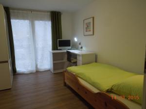 a bedroom with a bed and a desk with a computer at Ferienwohnung Merzenbühl in Bad Überkingen