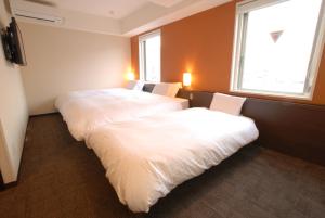 Postel nebo postele na pokoji v ubytování AB Hotel Kanazawa
