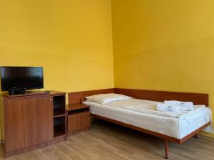 a small room with a bed and a flat screen tv at Meduza Natura Tour in Świnoujście