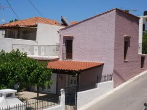 a white and pink house with a red roof at Christina's Villa with sea view in Daratso