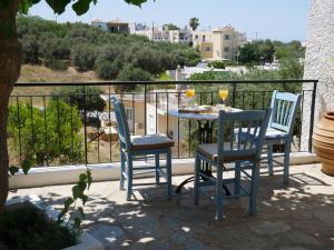 a table and chairs on a balcony with wine glasses at Christina's Villa with sea view in Daratso