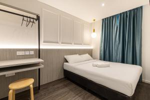 a small room with a bed and a chair at Philip Hotel at Little India in Singapore +26 photos