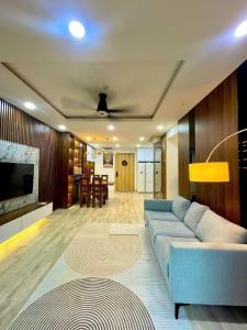 ein Wohnzimmer mit einer blauen Couch und einem Fernseher in der Unterkunft Apartment Celadon City Tân Phú - 2 PHÒNG NGỦ in Ho-Chi-Minh-Stadt + 14 Fotos