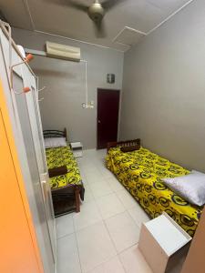 a room with two beds and a box at Pulai Bliss Homestay in Pekan Nanas